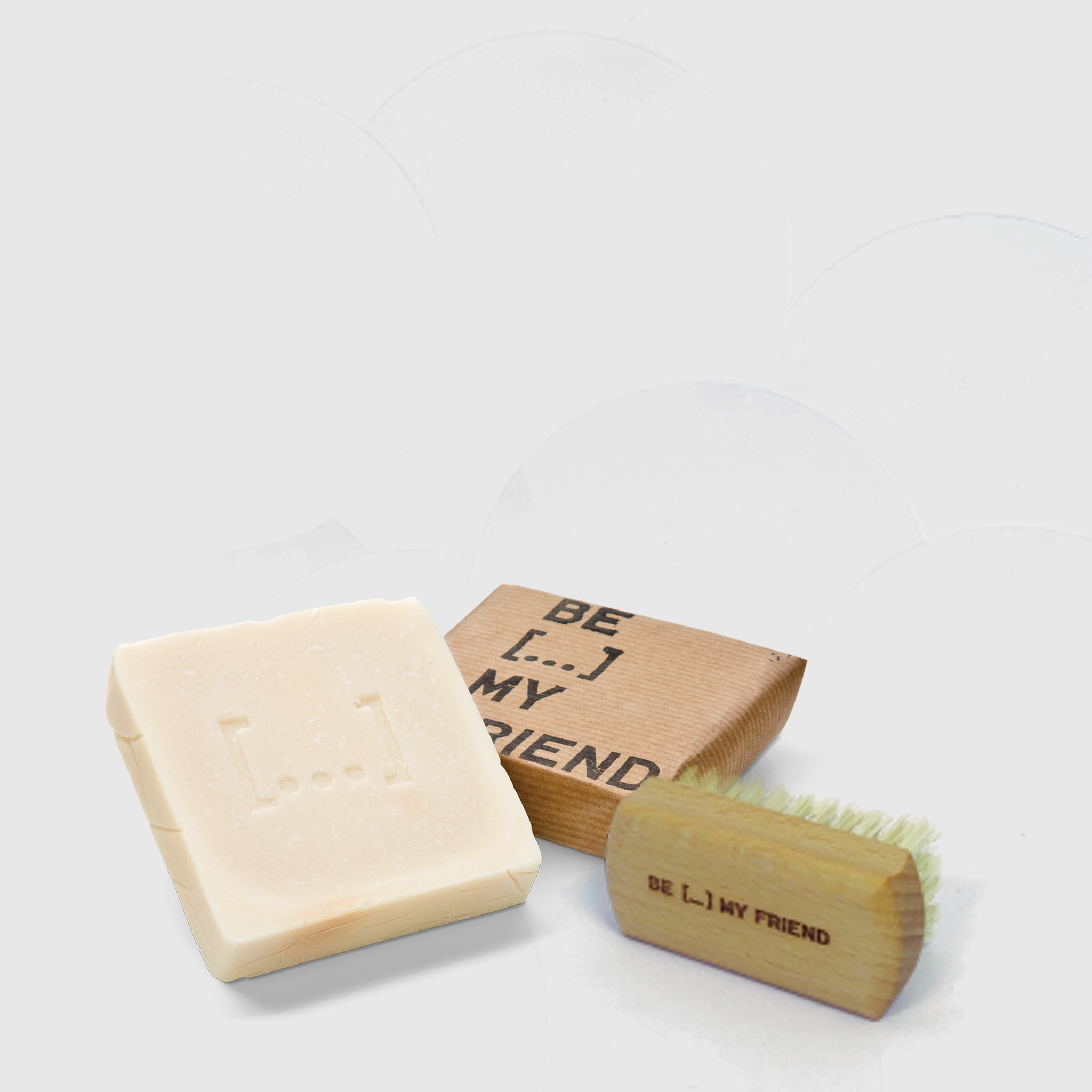 Natural beige soap bar with embossed logo next to wooden hand brush with bristles and "BE L.I.