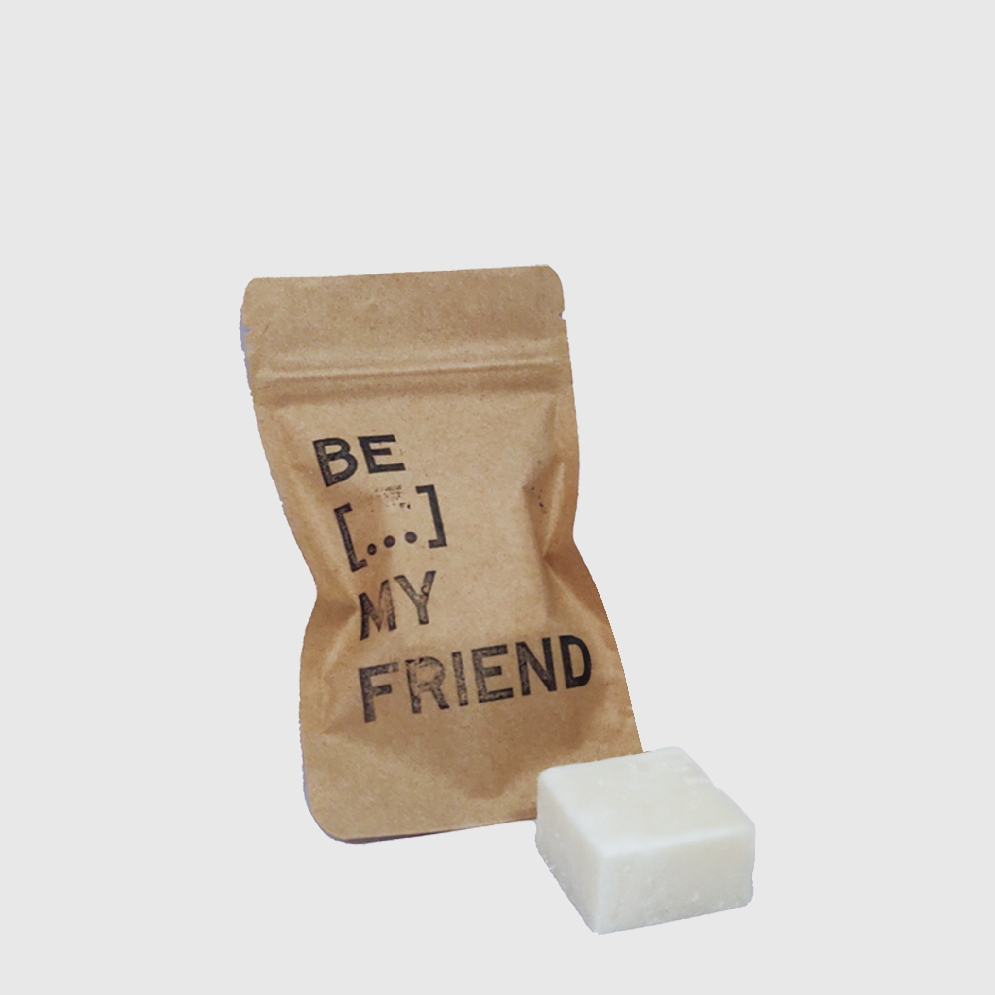 Natural square white soap bar next to brown kraft paper pouch with "Be My Friend" text.