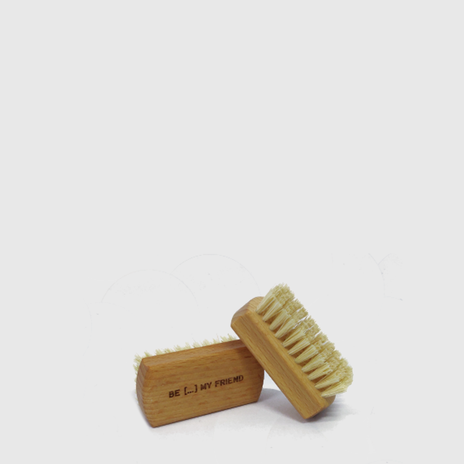 Wooden handheld brush with natural sisal bristles and engraved text on the side.