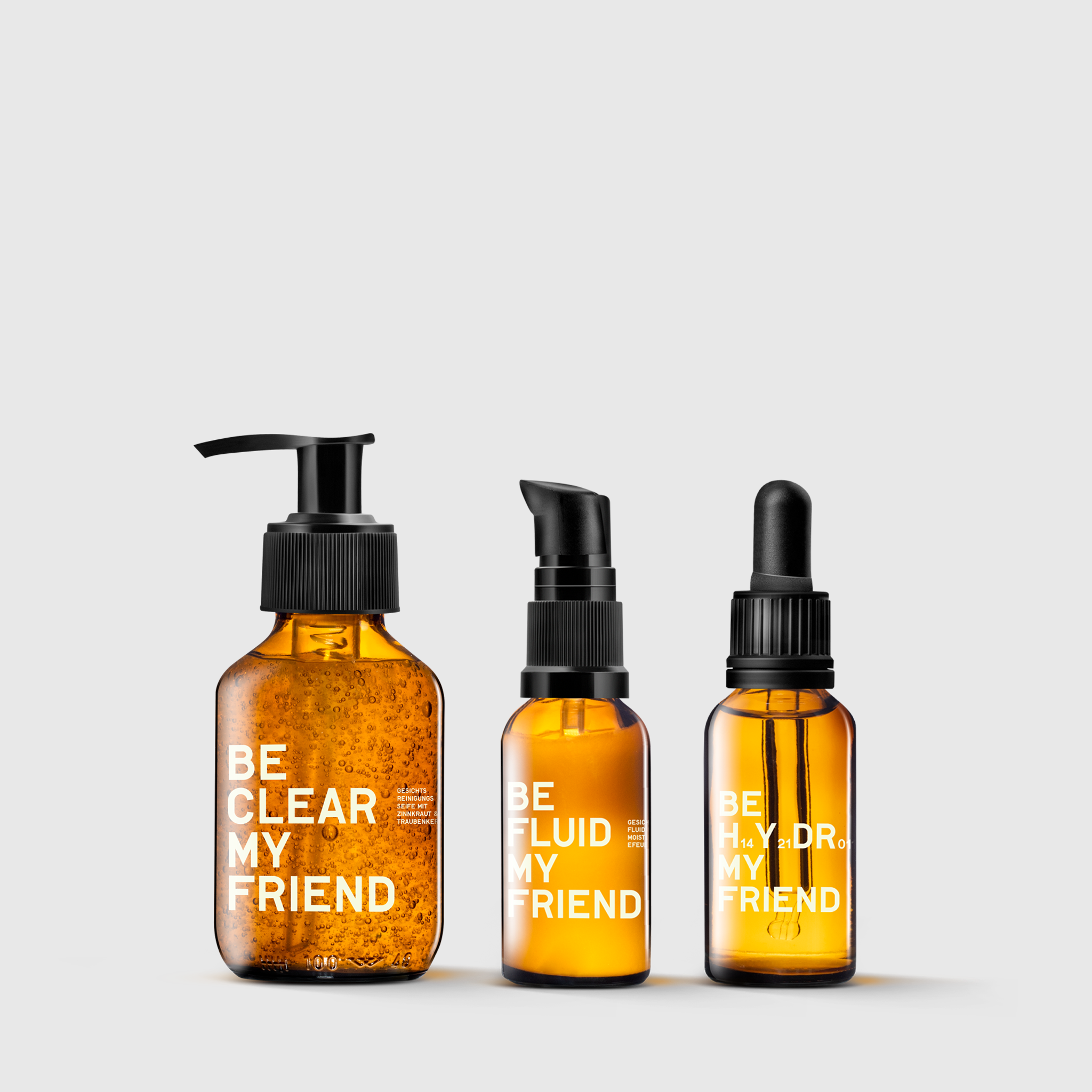 Amber glass skincare bottles with black pump, pump dispenser, and dropper labeled Clear, Fluid, and Hydro Set.