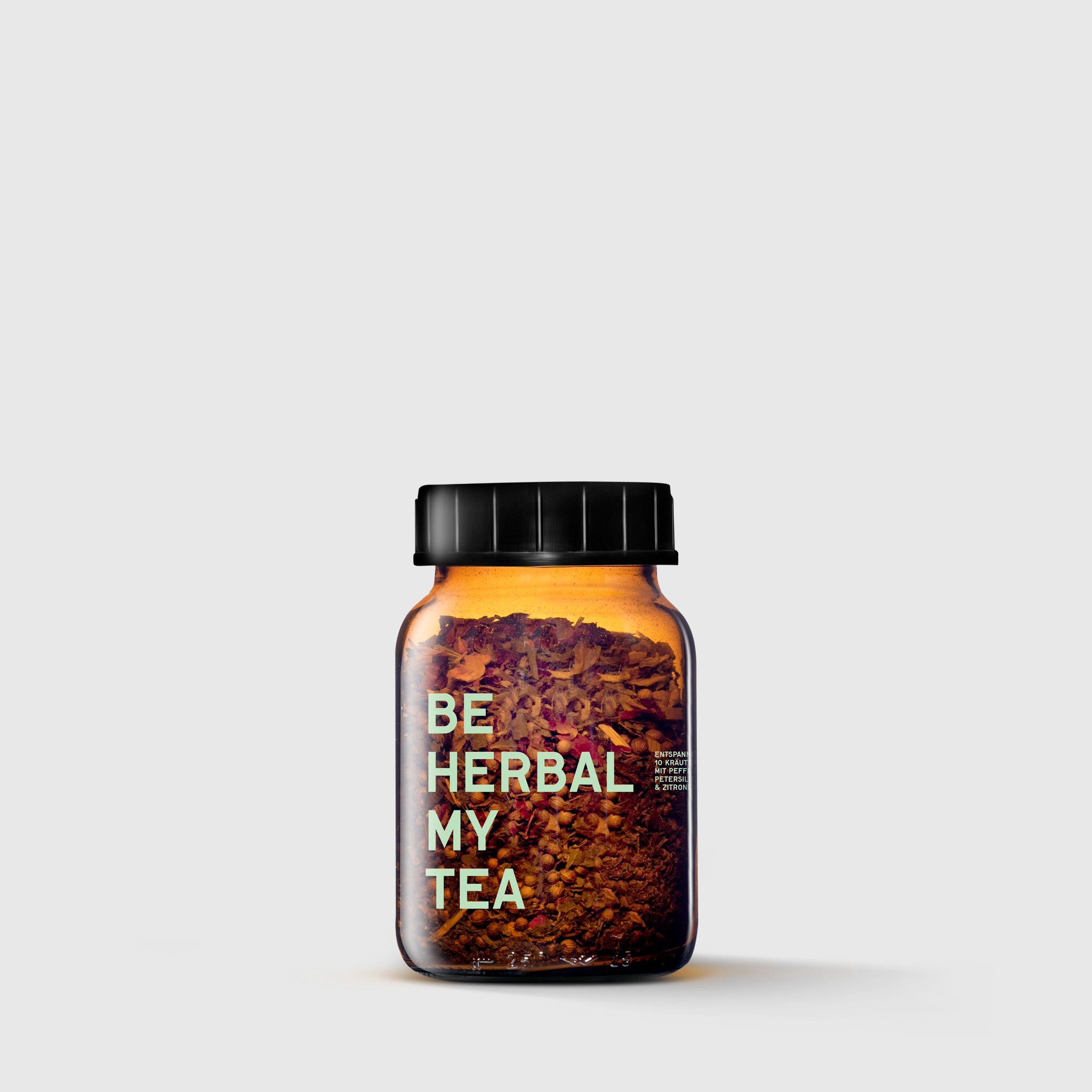 Amber glass jar with black lid labeled "Be Herbal My Tea" holding herbal tea blend.