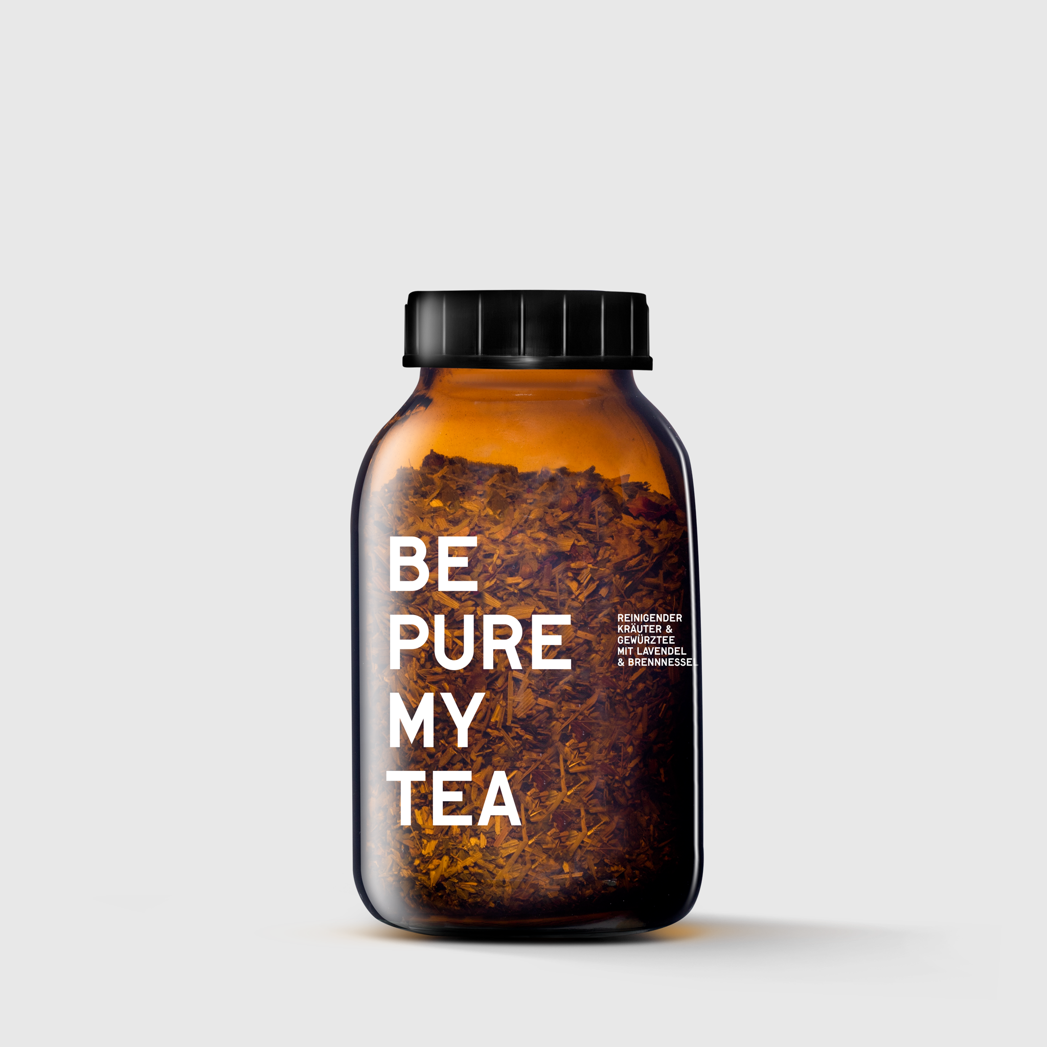 Amber glass jar with black lid filled with loose herbal tea labeled "Be Pure My Tea".