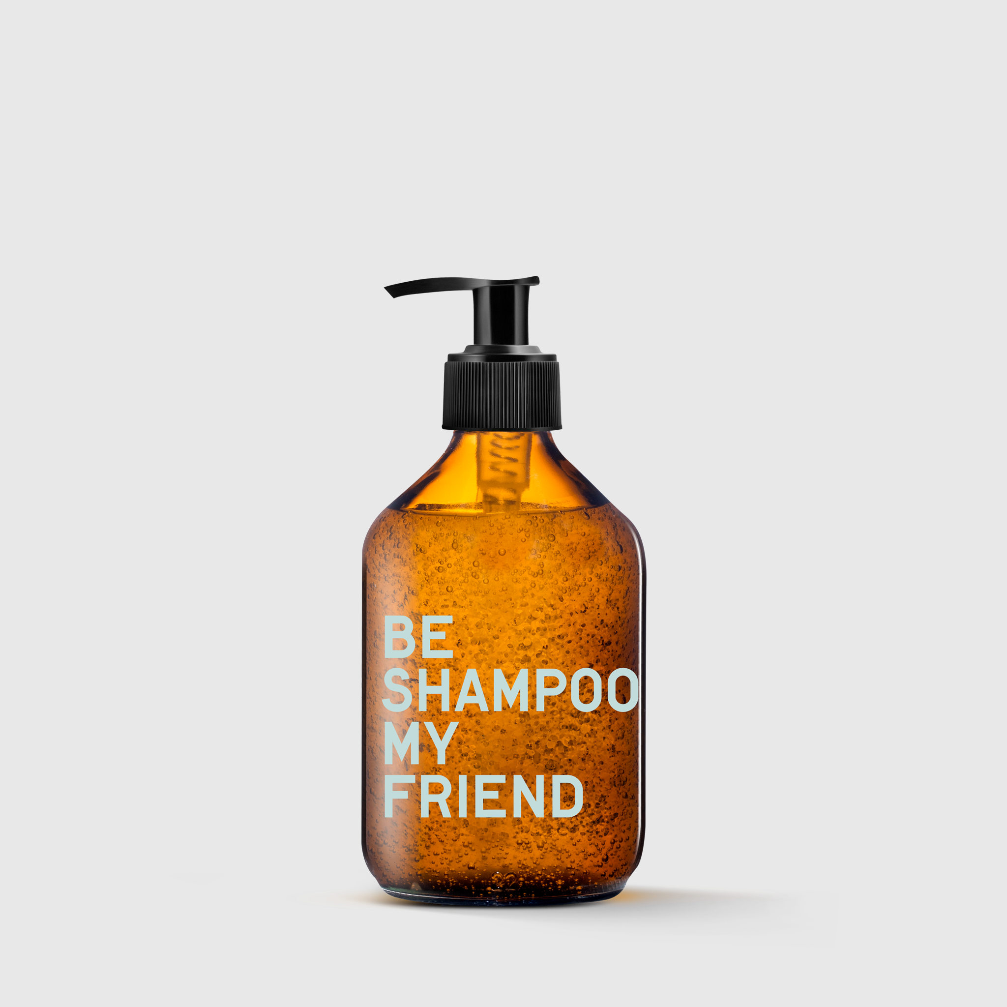 Amber translucent shampoo bottle with black pump and white text "BE SHAMPOO MY FRIEND".