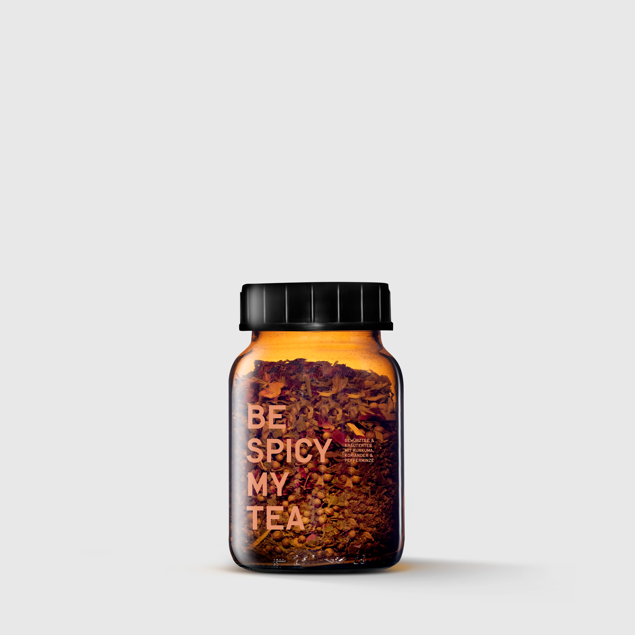 Amber glass jar with black lid containing mixed herbal spices labeled Be Spicy My Tea.