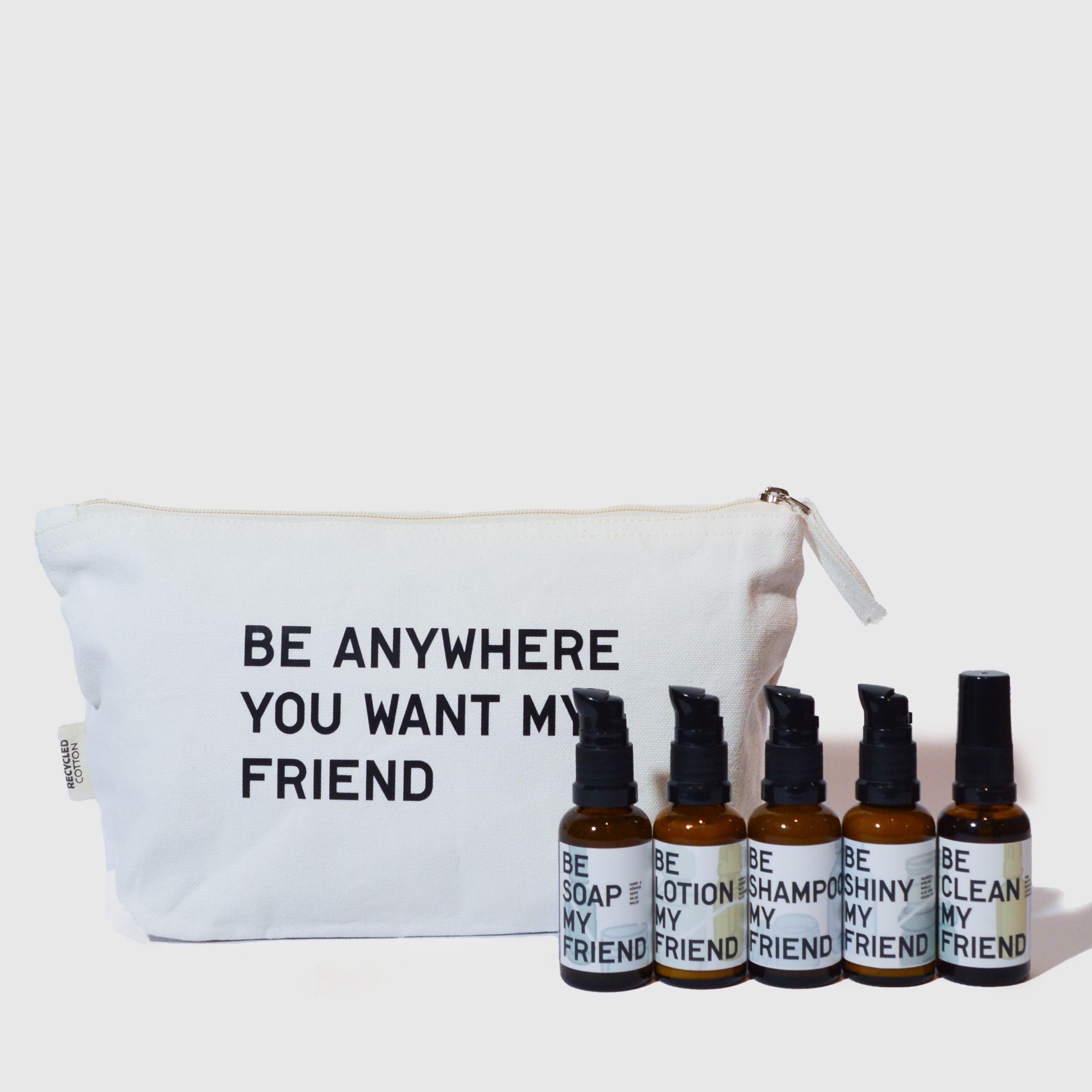 White travel pouch with black text "Be Anywhere You Want My Friend" and six small amber bottles with black pump caps labeled .