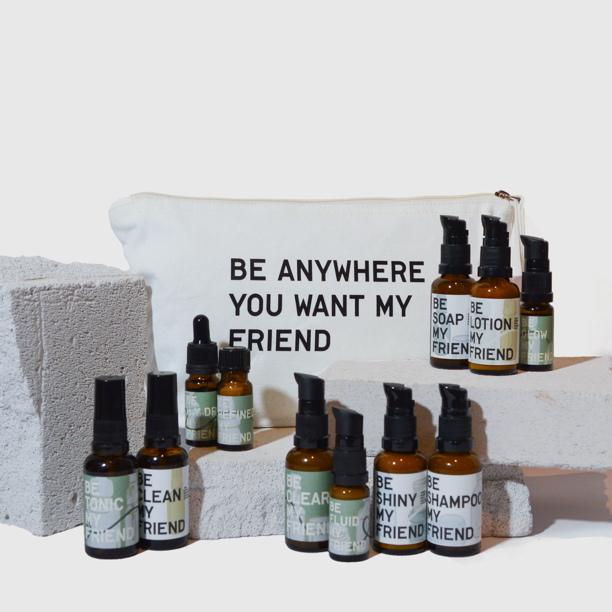 Travel set with amber glass bottles labeled soap, lotion, shampoo, and more, featuring black pump dispensers and a white one.