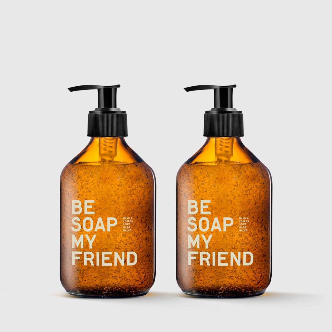 Two amber glass soap dispensers with black pumps and white &quot;BE SOAP MY FRIEND&quot; text.