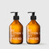 Two amber glass pump bottles labeled "BE LOTION MY FRIEND" with black dispensers on a light gray background.