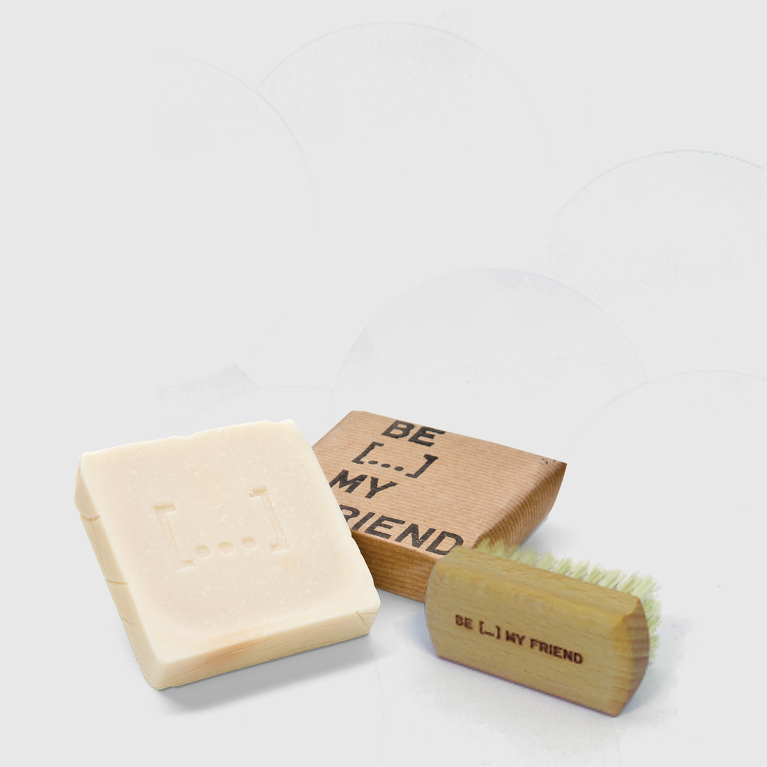 Natural beige soap bar with embossed logo next to wooden hand brush with bristles and "BE L.I.